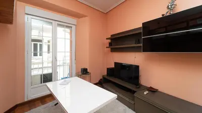 Una televisión o centro de entretenimiento en GuestReady - Cozy stay near Gran Via and Callao