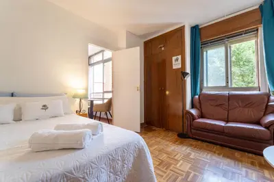 Cama o camas de una habitación en Central Madrid Apartment with Garden Views, Sunny Private Terrace, Fast WiFi & Metro Access