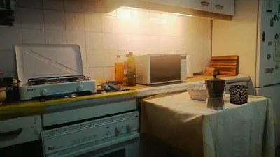 Una cocina o zona de cocina en habitación de 2 camas con 2 ventanas al exterior y TV en casa compartida