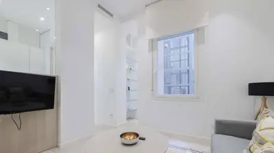 Una televisión o centro de entretenimiento en Warm 1BR in the Vibrant Chueca Neighborhood