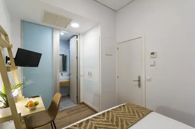 Una televisión o centro de entretenimiento en The Bridge Huertas - Hostal